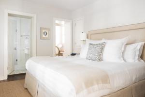 a white bedroom with a large bed with white pillows at Zero George Hotel in Charleston