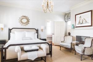 a bedroom with a bed and two chairs and a fireplace at Zero George Hotel in Charleston