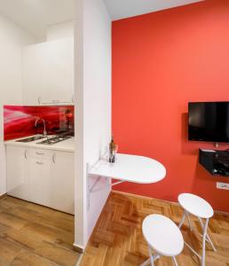 a kitchen with a white table and two white chairs at Apartments Postic in Osijek