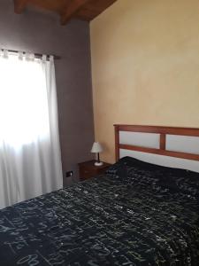 a bedroom with a bed and a window at La Casita De Lunlunta in Ciudad Lujan de Cuyo