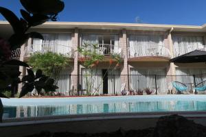 a building with a swimming pool in front of a building at Tweed Central Motel in Tweed Heads