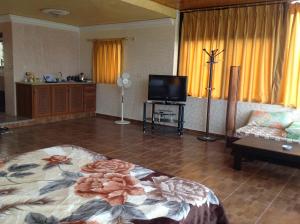 sala de estar con cama y TV en Murshed Motel, en Ash Shūnah ash Shamālīyah