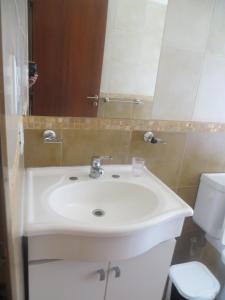 a bathroom with a white sink and a toilet at Reina de las Cortaderas in Merlo +23 photos