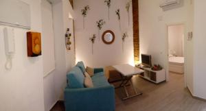 セビリアにあるAcogedor Apartamento en Triana Sevillaのリビングルーム(青いソファ、テーブル付)