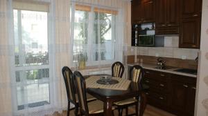 a kitchen with a table and chairs and a kitchen with a window at Willa Kamako in Międzyzdroje