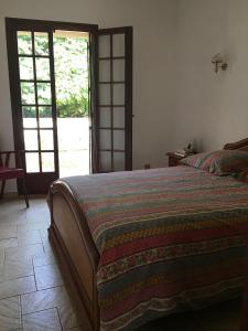 Schlafzimmer mit einem Bett und einer Glasschiebetür in der Unterkunft Maison Vigneronne in Loupian