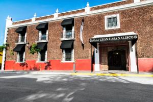 un edificio di mattoni rossi con un cartello che legge il villaggio di San Carlos Cash di Gran Casa Xalisco a Guadalajara