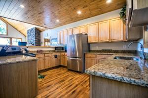 a kitchen with wooden cabinets and a stainless steel refrigerator at Eagle's Nest- A pet friendly cabin on the river! in Luray