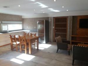 a dining room with a table and a kitchen at Calafate Hostel in El Calafate