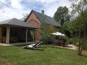 una casa con dos sillas sentadas en el patio en La Reine des Prés, en Marly-Gomont