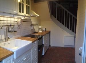 uma cozinha com um lavatório e um fogão forno superior em La Reine des Prés em Marly-Gomont
