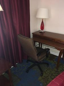 a room with a desk and a chair next to a desk with a lamp at Anchor Motel in Niagara Falls