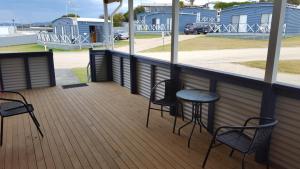 a patio area with chairs, tables and chairs at Scamander Tourist Park in Scamander