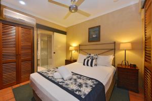 a bedroom with a bed and a ceiling fan at Seascape Apartments at Villa San Michele in Port Douglas