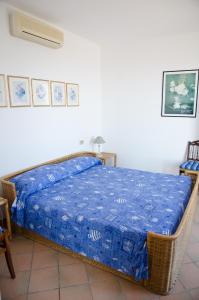 CipressaにあるHoliday Apartment by the sea - breathtaking locationのベッドルーム1室(青い毛布付きのベッド1台付)