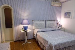 CipressaにあるSeaside holiday apartment - unique locationのベッドルーム1室(ベッド1台、ランプ付きテーブル付)