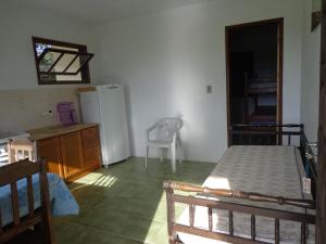 Habitación con cocina con cama y nevera. en Apartamento Sul na Praia da Ferrugem, en Garopaba