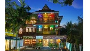 a large building with lights on the front of it at Kumarakom Wood Castle Serviced Appartments in Kumarakom