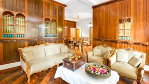 a living room with two chairs and a table at Kumarakom Wood Castle Serviced Appartments in Kumarakom