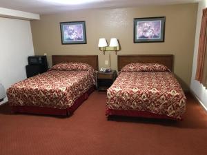 Ένα ή περισσότερα κρεβάτια σε δωμάτιο στο Travelers Inn
