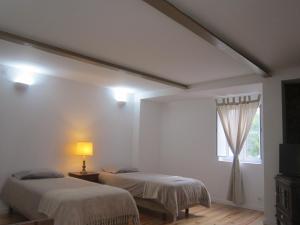 2 łóżka w białym pokoju z oknem w obiekcie Casa Zé Bonito I w mieście Cascais
