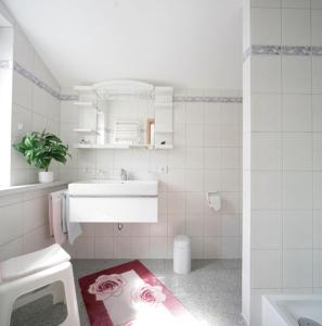 uma casa de banho branca com um lavatório e um lavatório em Ferienwohnung Sabrina em Oberstaufen