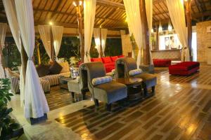 ein Wohnzimmer mit Sofas und Stühlen und ein Zimmer mit in der Unterkunft Grand Mega Resort & Spa in Cepu