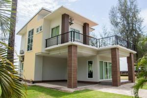 a house with a balcony on top of it at Hadthong Resort in Pak Phayun