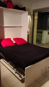 ラ・グランド・モットにあるStudio vue panoramique-centre villeの赤い枕が付いたベッドが備わる客室です。