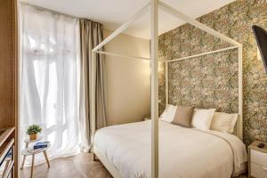 1 dormitorio con cama con dosel y ventana en RN _ Residenza Novecento, en Roma