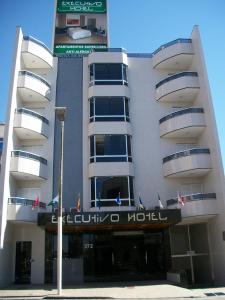 Executivo Hotel في مونتيس كلاروس: مبنى ابيض كبير فيه فندق