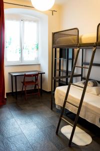 ジェノヴァにあるOTTO rossoの二段ベッド2台とテーブルが備わる客室です。