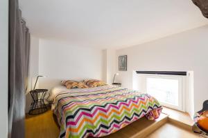 ニースにあるNicelidays - Le Suede - Carré d'or - 2min from beachesのカラフルなベッドと窓付きのベッドルーム1室が備わります。