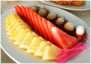 a plate of fruit and vegetables on a table at Hadthong Resort in Pak Phayun