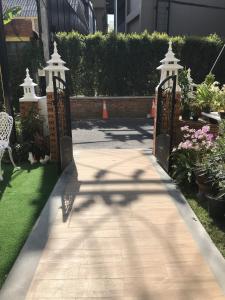 a walkway leading to a garden with a gate at Villa Thai Orchid (adult only) in Chiang Mai +33 photos