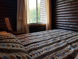 a bedroom with a bed with a quilt on it at Piracuacito in Paso de la Patria