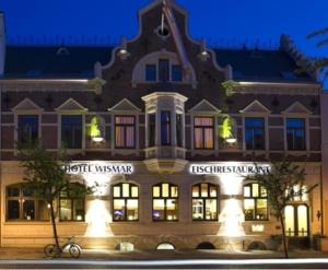 
a large building with a clock on the front of it at Restaurant & Hotel Wismar in Wismar
