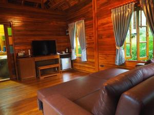 ein Wohnzimmer mit Ledercouch und Fernseher in der Unterkunft Doithinnan Resort in Nan