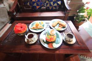 a table with plates of food and cups of coffee at Nova Homestay Ubud in Ubud