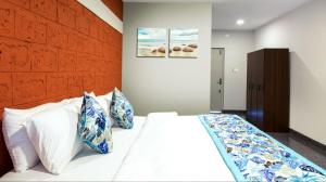Schlafzimmer mit einem Bett mit blauen und weißen Kissen in der Unterkunft Blue Ocean Sands - On the Beach in Kumta
