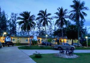 a house with palm trees and cars parked in a driveway at Hadthong Resort in Pak Phayun +32 photos