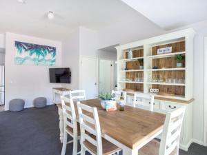 - une salle à manger avec une table et des chaises en bois dans l'établissement Fairway Haven Getaway, à Mollymook