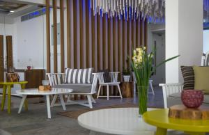 a lobby with chairs and tables and chandeliers at Island Boutique Hotel in Larnaca
