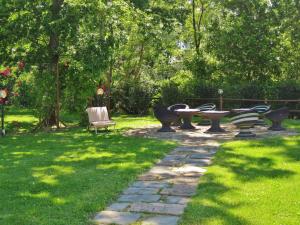 チェルタルドにあるLHP Hotel Certaldoの芝生の中にテーブルとベンチがある庭園