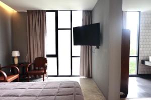 a hotel room with a bed and a flat screen tv at Antique Chiangmai in Chiang Mai