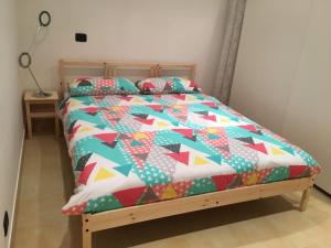 un letto con un piumone colorato e cuscini sopra di Interno 2 Il giardino segreto CENTRO a Bari