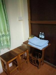 Huen Sabaidee Soi 8 في تشيانغ خان: غرفة بها طاولة عليها زجاجات ماء
