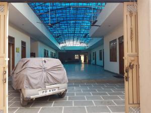 a car parked in a building with a cover on it at Shri Gaya Prasad Dham in Vrindāvan