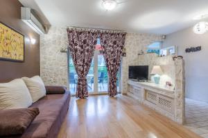 uma sala de estar com um sofá e uma televisão em Apartment Jeger em Povljana