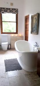 a bathroom with a large white tub and a toilet at Frieden-Hof Guest Accommodation in Penhill